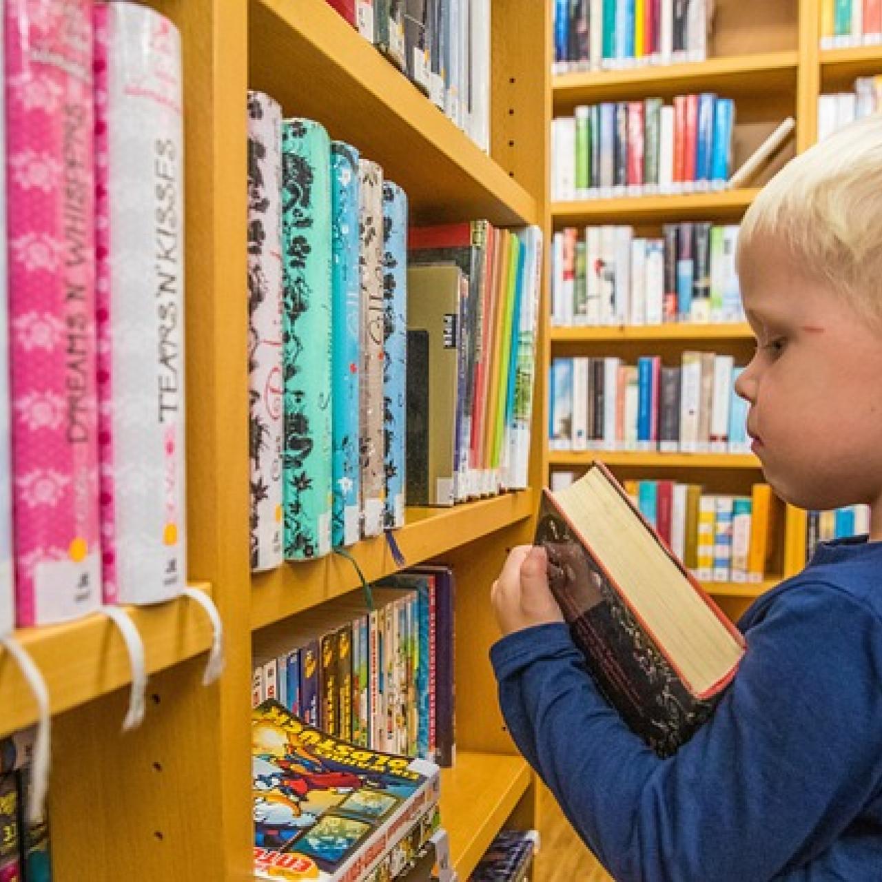 Kind vor Bücherregal